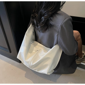 Vue détaillée du sac à bandoulière blanc brillant en forme de lune avec fermeture éclair