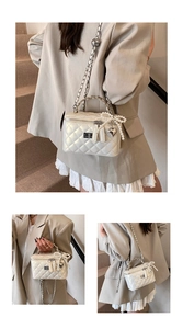 Detail of white quilted box bag with pearl bow charm and silver chain strap