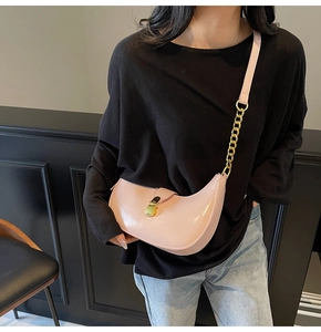 Pink crescent shoulder bag in glossy patent leather with gold chain strap detail