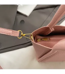 Close-up of pink litchi grain leather texture and premium gold hardware on the handbag
