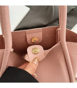 Detailed close-up of the magnetic closure and lychee grain texture on a pink bucket bag