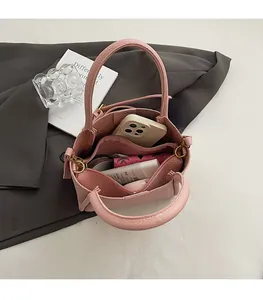Macro view of pink lychee leather bucket bag showing spacious interior with zipper pocket