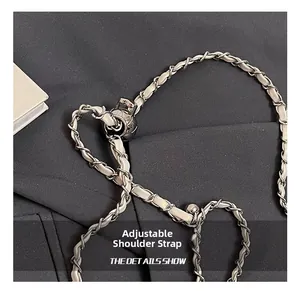 Detail of adjustable metal chain shoulder strap with gold ball slider and leather trim