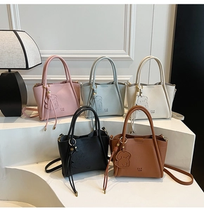 Detail of trendy bucket bags in various colors featuring cute puppy charm and pebbled leather