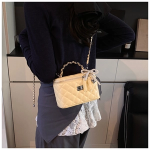 Quilted mini trunk bag in bright yellow with pearl bow detail and gold chain strap