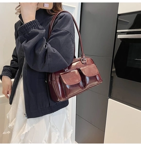 Dettaglio borsa a spalla bordeaux lucida con doppie tasche anteriori e chiusura lampo