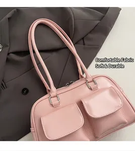 Close-up of pink Boston bag with double pockets and silver metal zippers on grey blazer