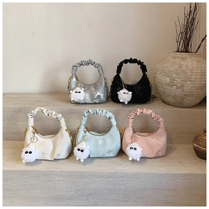 Group display of colorful pleated satin dumpling bags with chain straps and fur charms