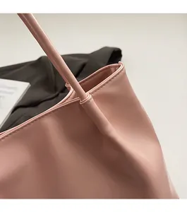 Detail of pink PU leather tote showing precise stitching and handle connection