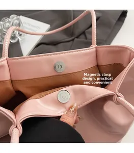 Detail of pink tote bag with secure magnetic clasp closure and brown fabric lining