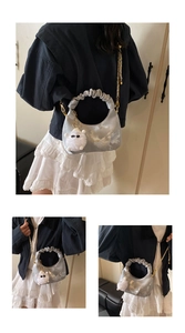 Detail of silver-grey tie-dye pleated handbag with gold chain and white plush charm