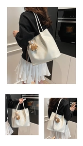Detail of white glossy PU leather tote bag featuring a cute plush bear charm decoration