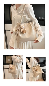 Close-up of beige glossy leather tote bag featuring a cute teddy bear plush charm