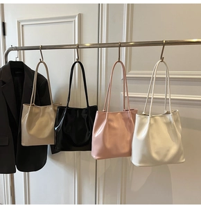 Close-up of stylish glossy leather tote bags in khaki, black, pink, and beige colors