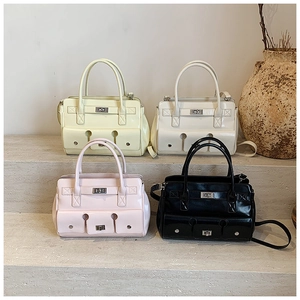 Détail de quatre sacs à main en cuir verni brillant en jaune, crème, rose et noir