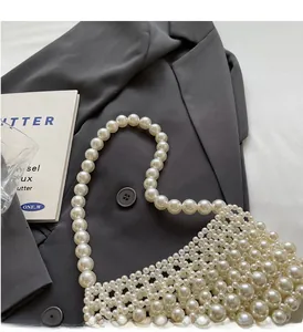 Detail of handcrafted white pearl crossbody bag with lustrous beads and sturdy weave