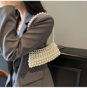 Detail view of a handmade pearl crossbody bag featuring glossy cream beads and textured weaving