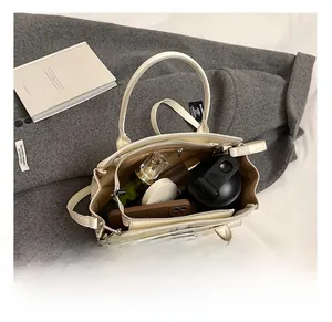 Vue intérieure du sac bandoulière crème montrant les compartiments et la poche zippée
