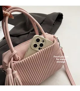 Detailed view of pink pleated handbag showing front pocket storage and textured finish