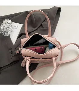 Top view of pink litchi grain crossbody bag showing interior space and accessories