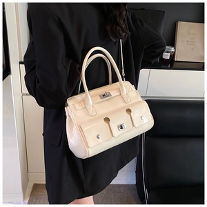 Détail du sac à main en cuir verni crème avec double poche et verrous rotatifs argentés
