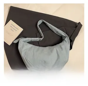 Détails d'un sac bandoulière en toile bleue en forme de lune avec sangle réglable