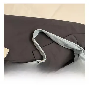 Détail du sac cabas en toile bleu clair avec poignées robustes et boucles métalliques