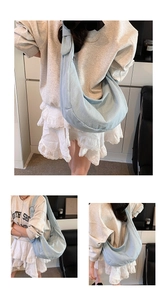 Détail du grand sac croissant en denim bleu clair montrant la texture et la fermeture