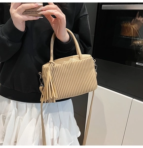 Détail du sac seau plissé kaki clair avec longues franges et bandoulière amovible