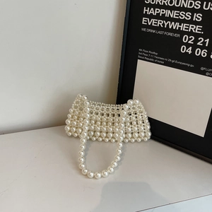 Handmade white pearl woven crossbody bag featuring an elegant trapezoid structure and handle