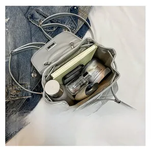 Top view showing the large internal capacity of the silver quilted bucket bag with essentials