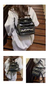 Detail of black quilted leather backpack with metal chain straps and front square lock
