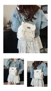 Detailed view of white quilted mini backpack with leather-interwoven chain straps
