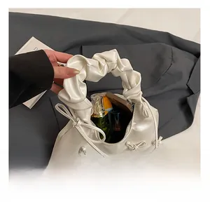 Detail showing the large interior capacity of this white pleated tote bag with bows