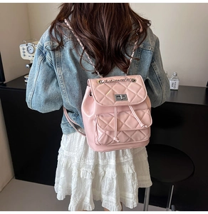 Detailed view of pink quilted mini backpack with chain straps and silver twist lock closure