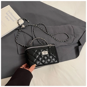 Detail of black quilted leather box bag with silver metal lock and chain strap