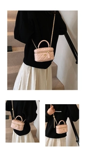 Detailed close-up of pink quilted mini box bag with gold flower hardware and chain strap