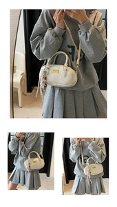 Details der weißen Bowling-Handtasche mit goldener Hardware, Perlenanhänger und Gurt