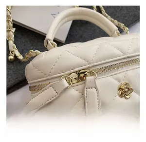 Detailed close-up of white quilted leather bag with golden hardware and floral clasp