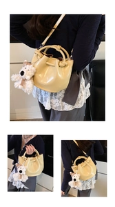 Stylish yellow patent leather bucket bag with cute puppy pendant, versatile shoulder crossbody.