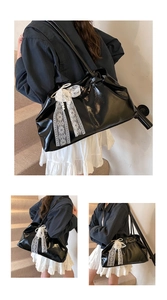 Detail of black faux leather tote bag with white lace bow and elegant pearl pendant