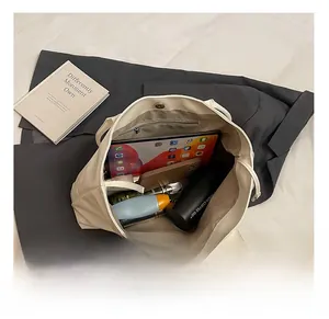Macro view showing large storage space with zipper pocket and magnetic buckle of tote bag