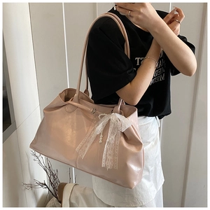 Detailed shot of pink faux leather tote with lace bow and elegant pearl charm