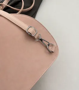 Dettaglio della borsa in pelle rosa con fibbie in metallo argento e cuciture precise
