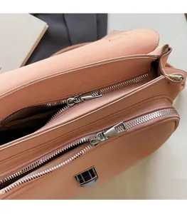 Detail of pink messenger bag featuring smooth double silver metal zippers and premium leather