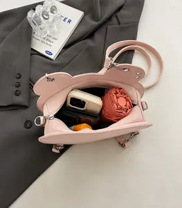Vista macro dell'interno della borsa in pelle rosa con spazio per cellulare e ombrello