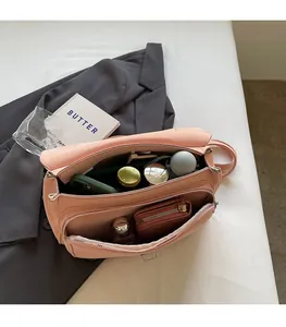 Detail view of pink flap crossbody bag with multi-compartment interior for large capacity