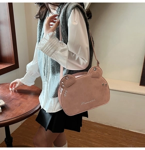 Dettaglio della borsa a tracolla a forma di orso in pelle rosa con ricamo Princess indosso
