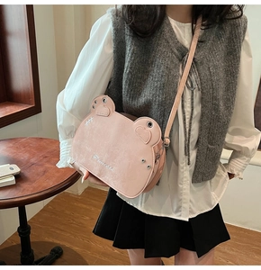 Pink frog-shaped leather bag with Princess embroidery and adjustable strap on a model