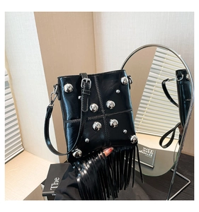 Dettaglio della borsa punk nera con borchie argentate e lunghe nappe a frangia